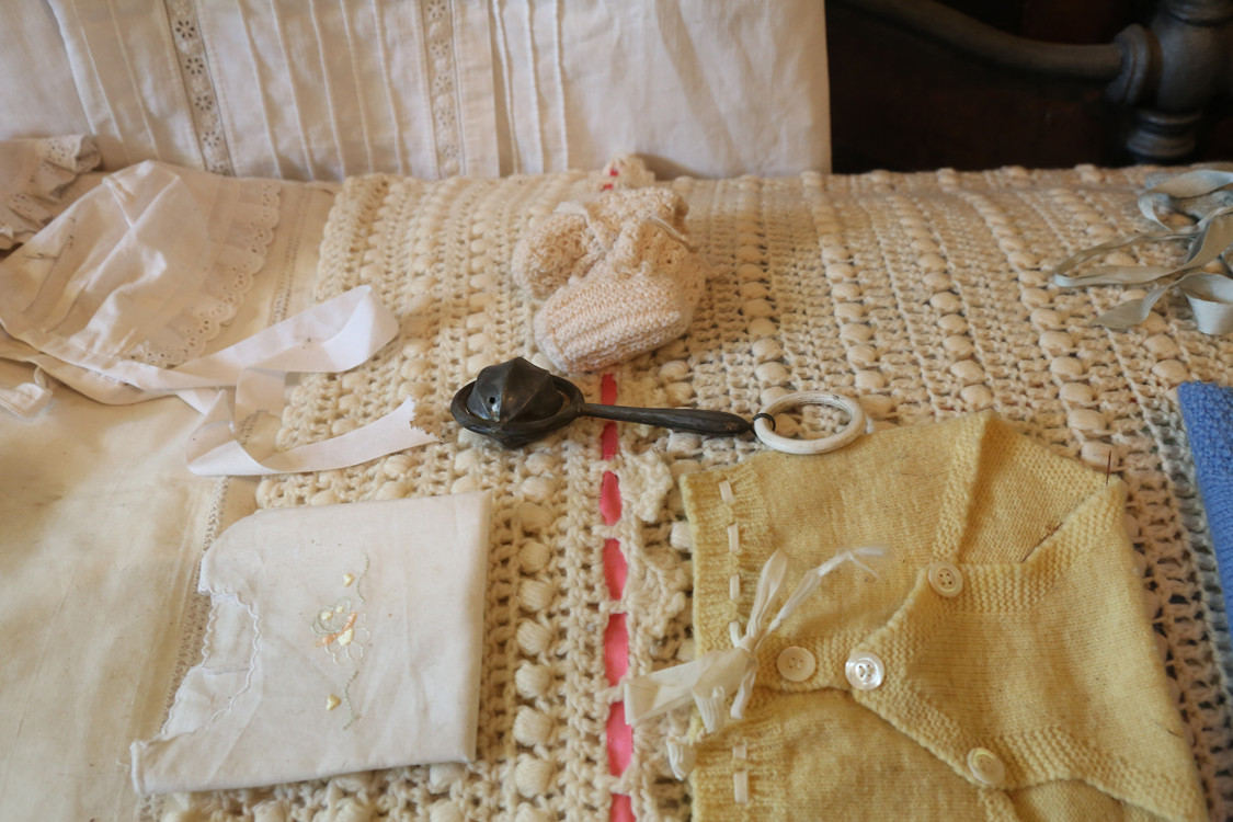 MuseoMemoria_060.jpg - IJE' NAJE NA MASNA'  - C&UumlNA CON FASCE, CAMISINE, CAUSETIN, SCUFIOT E CIUCHIN La nascita di un bambino - Culla con fasce, camicine, calzette, cuffiette e sonaglino