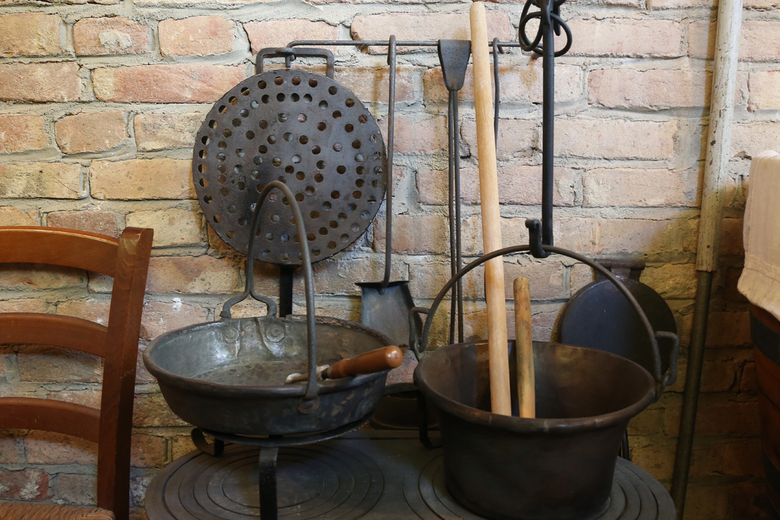 MuseoMemoria_134.jpg - STIVA ED GHISA, PAIRO DA PULENTA E PAIJELA, TUIRUN PER GIRE' LA PULENTA Stufa di ghisa, paiolo per la polenta e padella, bastone di legno per girare la polenta