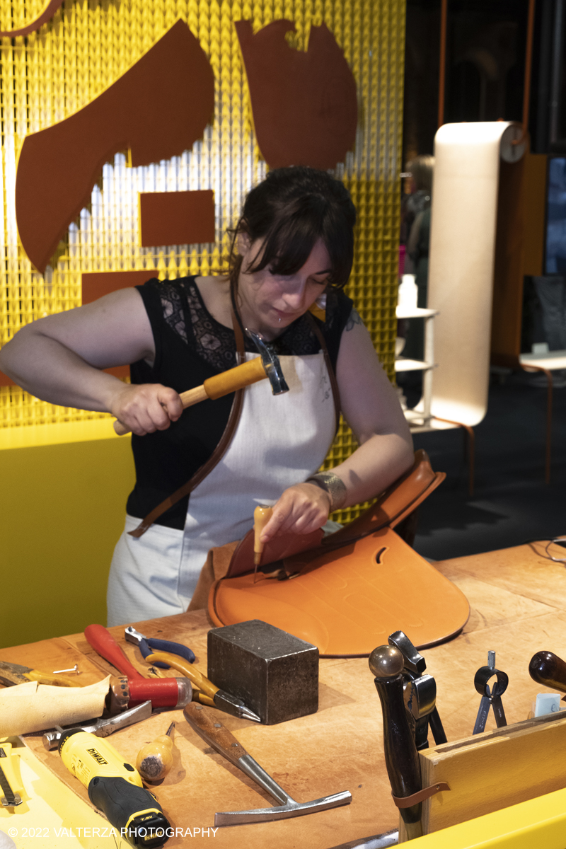 _DSF0941.jpg - 22/05/2022. Torino. Undici artigiani appartenenti a dieci mÃ©tier della maison HermÃ¨s sono arrivati alle Ogr con le loro borse degli attrezzi ed i loro materiali per mostrare i loro savoir-faire. Nella foto una artigiana HermÃ¨s realizza ed illustra la costruzione di una sella.