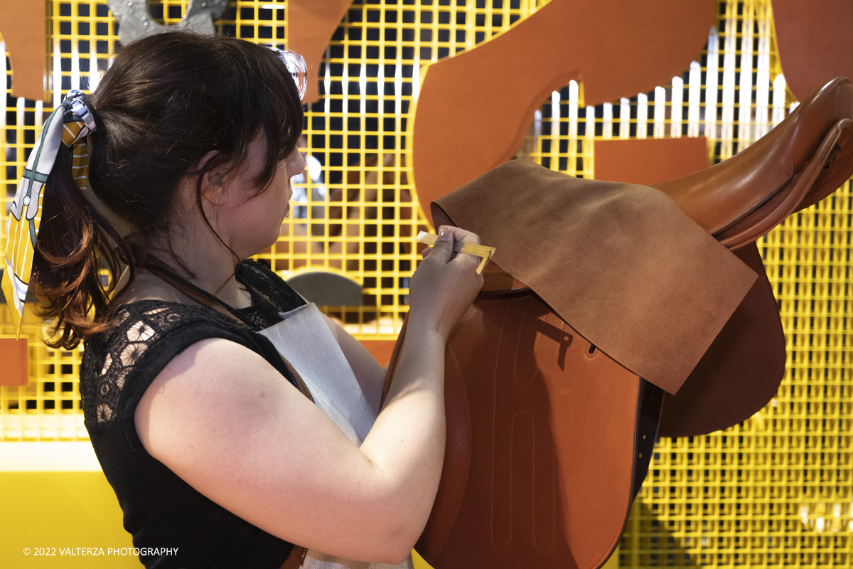 _DSF0960.jpg - 22/05/2022. Torino. Undici artigiani appartenenti a dieci mÃ©tier della maison HermÃ¨s sono arrivati alle Ogr con le loro borse degli attrezzi ed i loro materiali per mostrare i loro savoir-faire. Nella foto una artigiana HermÃ¨s realizza ed illustra la costruzione di una sella.