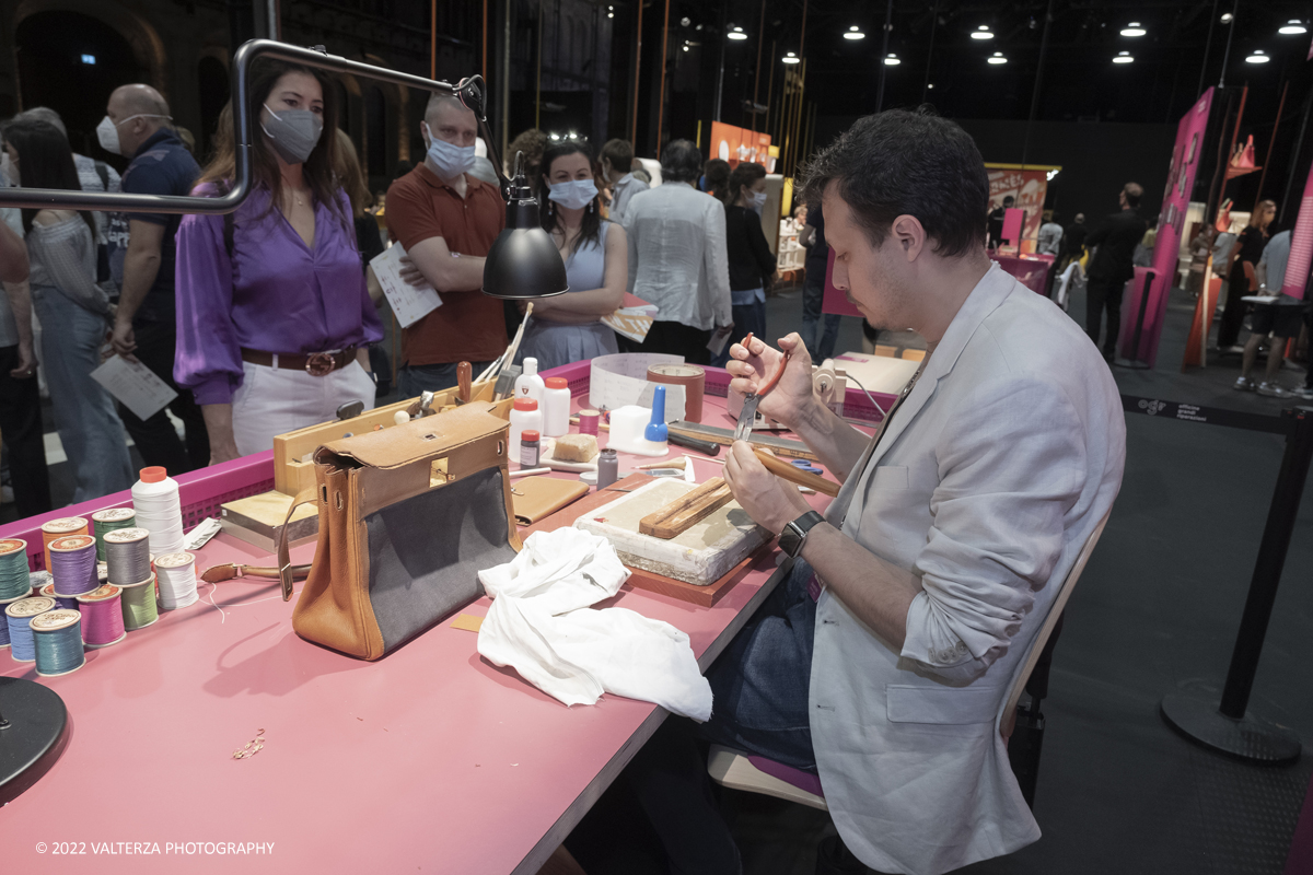 _DSF1384.jpg - 22/05/2022. Torino. Undici artigiani appartenenti a dieci mÃ©tier della maison HermÃ¨s sono arrivati alle Ogr con le loro borse degli attrezzi ed i loro materiali per mostrare i loro savoir-faire. Nella foto un artigiano HermÃ¨s illustra le metodologie di riparazione di prodotti usurati o danneggiati, nel 2020 gli artigiani Hermes hanno eseguito piÃ¹ di 120.000 riparazioni