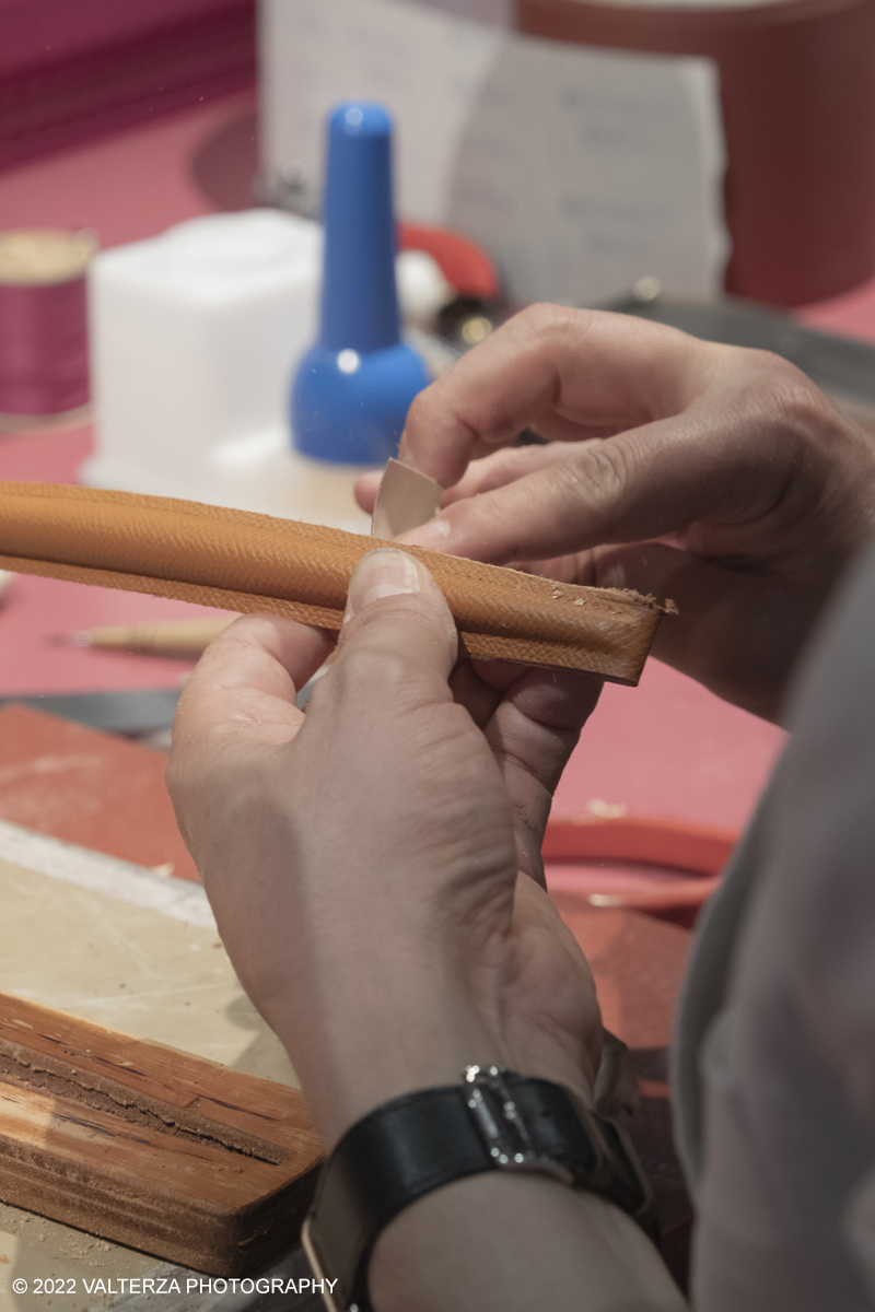 _DSF1398.jpg - 22/05/2022. Torino. Undici artigiani appartenenti a dieci mÃ©tier della maison HermÃ¨s sono arrivati alle Ogr con le loro borse degli attrezzi ed i loro materiali per mostrare i loro savoir-faire. Nella foto un artigiano HermÃ¨s illustra le metodologie di riparazione di prodotti usurati o danneggiati, nel 2020 gli artigiani Hermes hanno eseguito piÃ¹ di 120.000 riparazioni