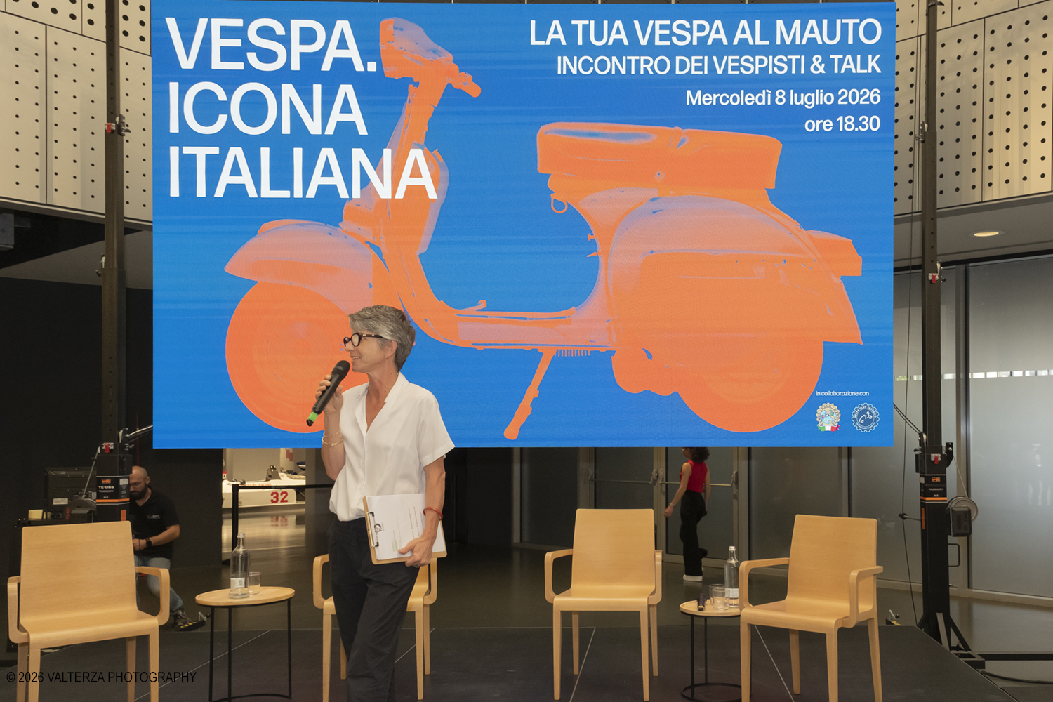 _DSF6264.jpg - 08/07/2026. Torino. In occasione della mostra VESPA. ICONA ITALIANA, il Museo Nazionale dellâ€™Automobile accoglie tutti i vespisti a vivere unâ€™esperienza esclusiva: per una sera la Piazza coperta del MAUTO ospita le Vespa dei partecipanti, che avranno lâ€™opportunitÃ  unica di esporre il proprio mezzo allâ€™interno del Museo, diventando protagonisti delle celebrazioni dedicate agli 80 anni di unâ€™autentica icona del design e della mobilitÃ  italiana. Nella foto Lorenza Bravetta Direttrice del MAUTO ed animatrice dell'evento chiama sul palco i partecipanti al Talk