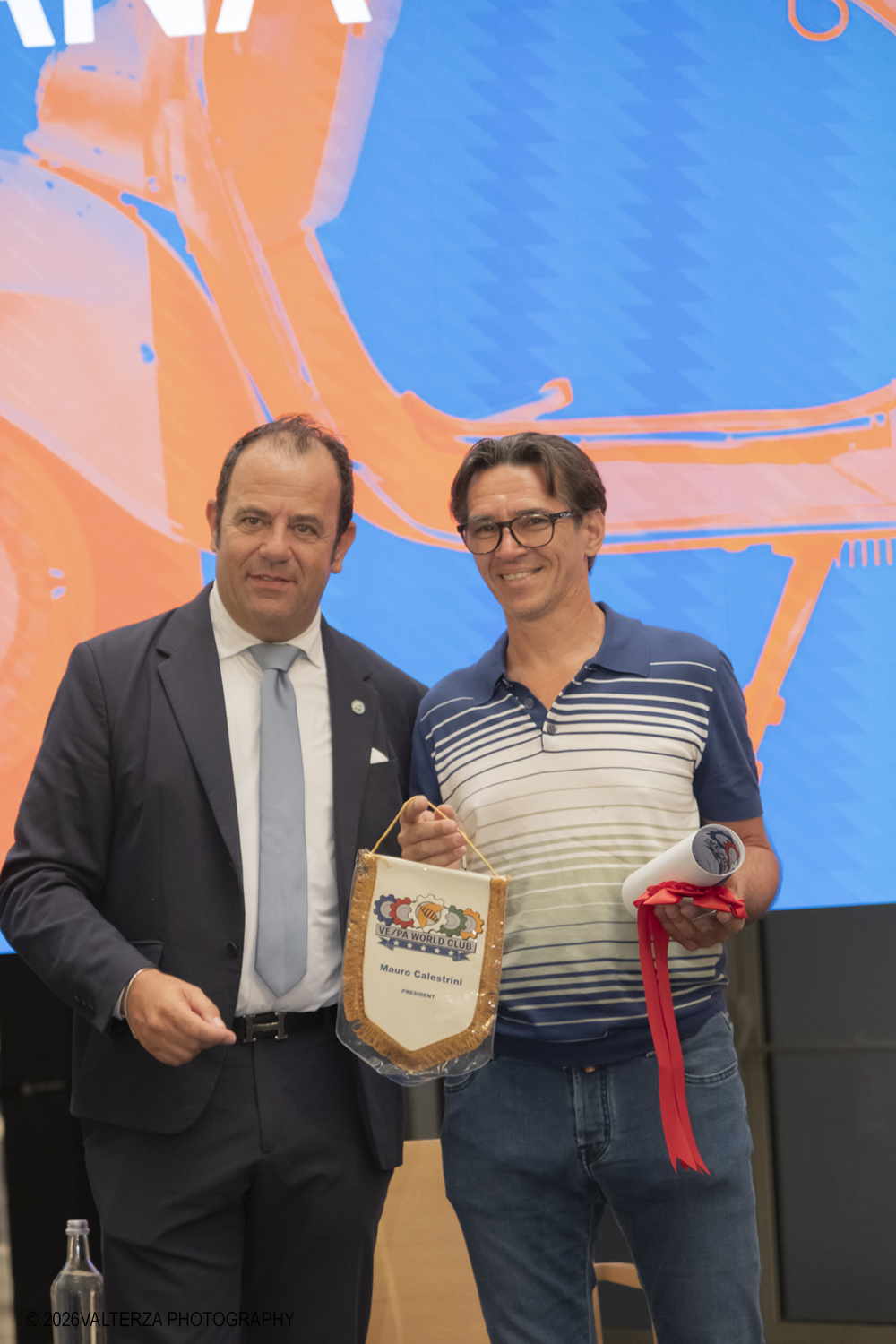 _DSF6341.jpg - 08/07/2026. Torino. In occasione della mostra VESPA. ICONA ITALIANA, il Museo Nazionale dellâ€™Automobile accoglie tutti i vespisti a vivere unâ€™esperienza esclusiva: per una sera la Piazza coperta del MAUTO ospita le Vespa dei partecipanti, che avranno lâ€™opportunitÃ  unica di esporre il proprio mezzo allâ€™interno del Museo, diventando protagonisti delle celebrazioni dedicate agli 80 anni di unâ€™autentica icona del design e della mobilitÃ  italiana. Nella foto Mauro Calestrini Presidente del Vespa World Club omaggia Mario Fumagalli