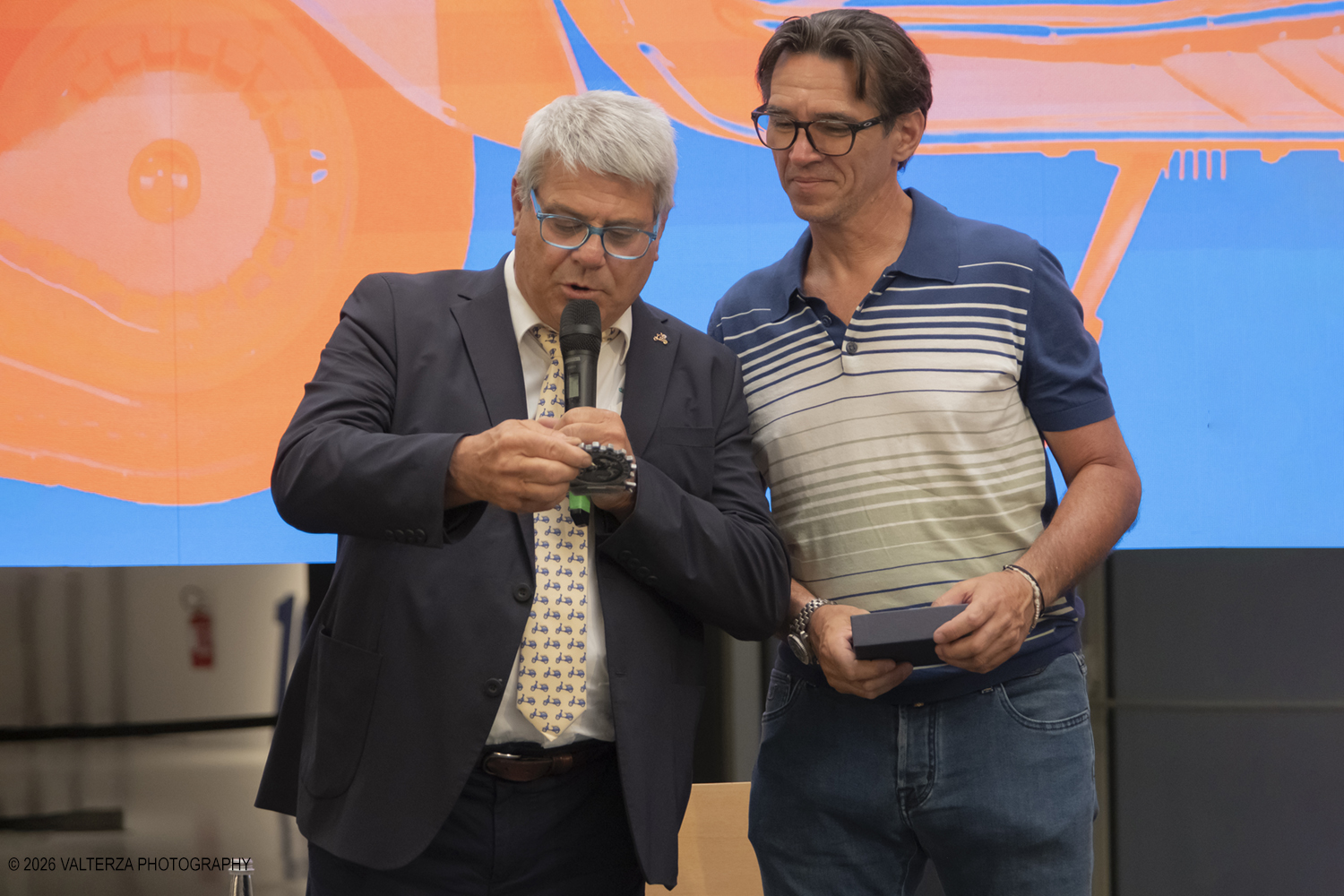 _DSF6352.jpg - 08/07/2026. Torino. In occasione della mostra VESPA. ICONA ITALIANA, il Museo Nazionale dellâ€™Automobile accoglie tutti i vespisti a vivere unâ€™esperienza esclusiva: per una sera la Piazza coperta del MAUTO ospita le Vespa dei partecipanti, che avranno lâ€™opportunitÃ  unica di esporre il proprio mezzo allâ€™interno del Museo, diventando protagonisti delle celebrazioni dedicate agli 80 anni di unâ€™autentica icona del design e della mobilitÃ  italiana. Nella foto Il presidente del Vespa Club d'Italia Leonardo Pilati omaggia Marco Fumagalli