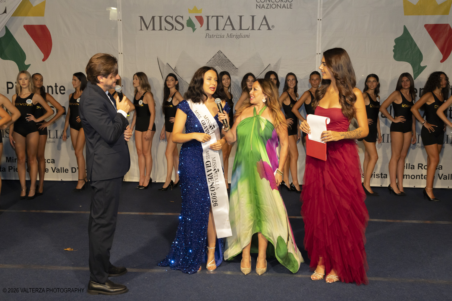 _Z3A7109.jpg - 08/08/2026. Giaveno . Finale Regionale di Miss Cinema Piemonte e Valle d'Aosta nonchÃ© lâ€™elezione di Miss sport Givova e Miss Giaveno che ha visto trionfare rispettivamente Carlotta Anguilano, Nicole Medini, e Martina Viglierco. Nella foto il momento del passaggio delle consegne tra la precedente miss Giaveno Ludovica Iacobellis e la nuova eletta Marina Viglierco con la esclusivista regionale Mirella Rocca ed i presentatori  Francesca Spinelli ed  Andrea Beltramo