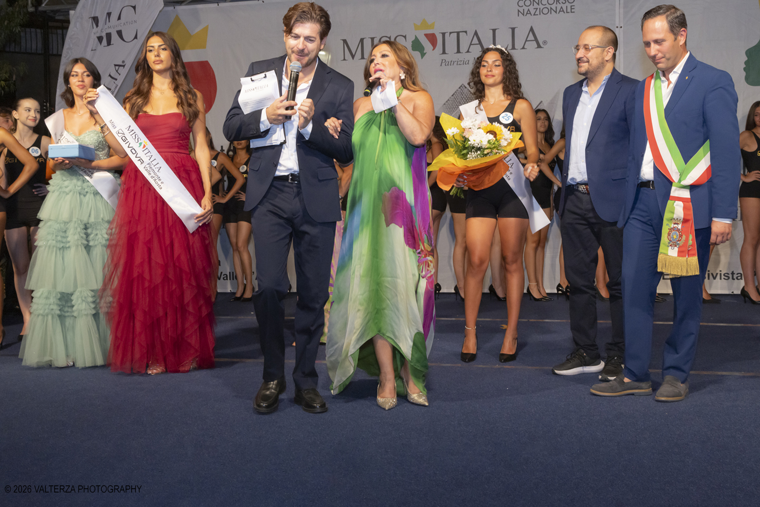 _Z3A7266.jpg - 08/08/2026. Giaveno . Finale Regionale di Miss Cinema Piemonte e Valle d'Aosta nonchÃ© lâ€™elezione di Miss sport Givova e Miss Giaveno che ha visto trionfare rispettivamente Carlotta Anguilano, Nicole Medini, e Martina Viglierco. Nella foto la nomina di Miss Givova  con la esclusivista regionale Mirella Rocca  i presentatori  e le autoritÃ  istituzionali
