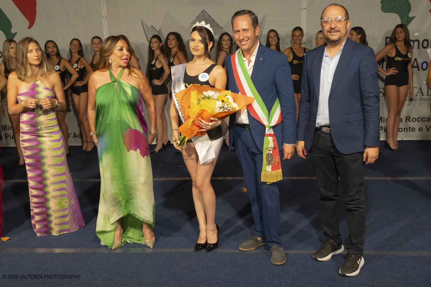 _Z3A7303.jpg - 08/08/2026. Giaveno . Finale Regionale di Miss Cinema Piemonte e Valle d'Aosta nonchÃ© lâ€™elezione di Miss sport Givova e Miss Giaveno che ha visto trionfare rispettivamente Carlotta Anguilano, Nicole Medini, e Martina Viglierco. Nella foto la nomina di Miss Givova con la esclusivista regionale Mirella Rocca  i presentatori  e le autoritÃ  istituzionali