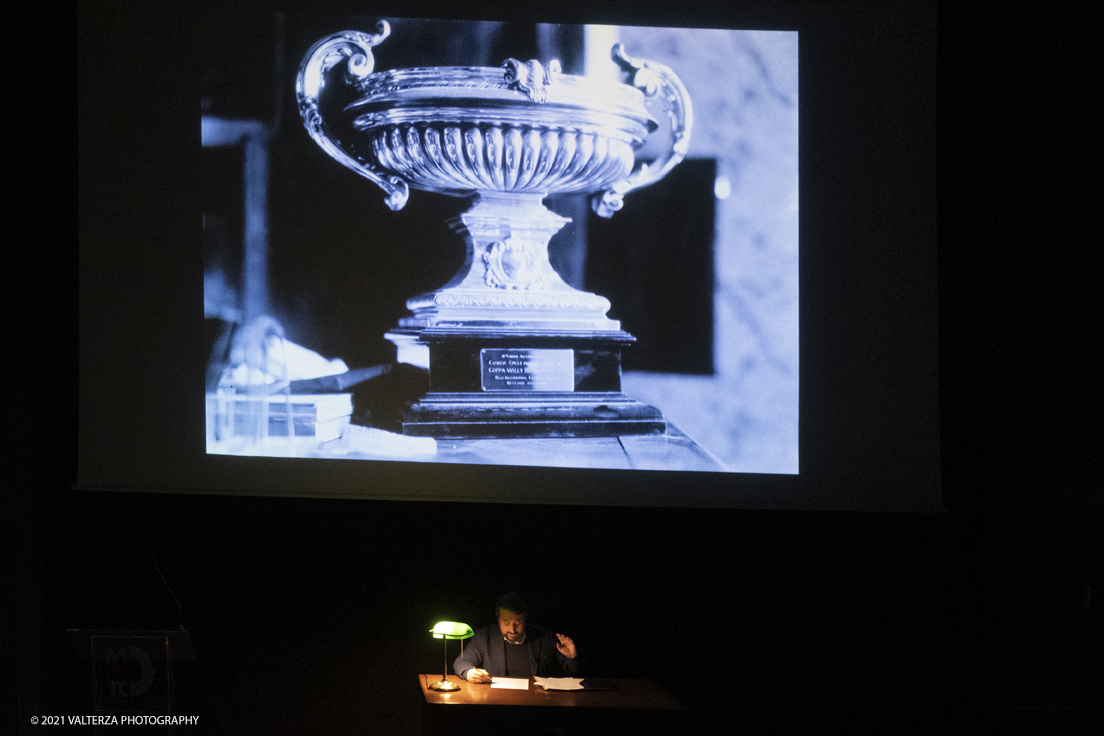 _DSF5772.jpg - 26/10/2021. Torino. Una mostra fotografica con le immagini del fotografo Adriano Scoffone racconta gli anni â€˜20 e â€˜30 della Provincia Granda e gli audaci piloti della Cuneo - Colle della Maddalena Nuvolari, Varzi, Campari e diversi altri. Nella foto mentre vengono proiettate alcune delle 80 immagini costituentti la mostra l'attore Paolo Giangrasso legge una immaginaria lettera scritta da Varzi alla mogglie carolina