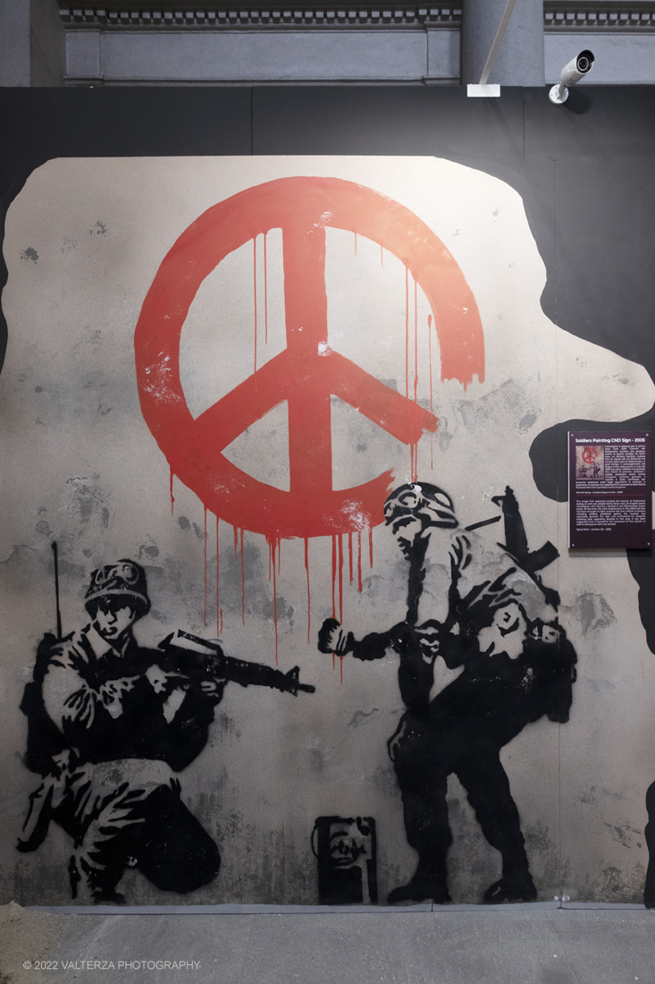 _DSF4872.jpg - 24/02/2022. Torino. Il percorso della mostra presenta oltre 90 opere di cui 30 murales a grandezza naturale realizzati da giovani street artist internazionali che raccontano il mondo del misterioso artista britannico, famoso per affrontare con ironia temi politici e di denuncia sociale. Nella foto opera painting CND sign 2006