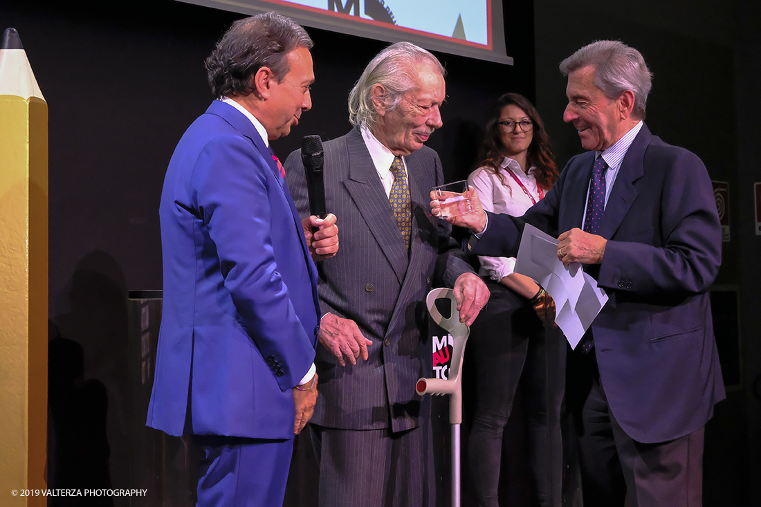 _DSF1381.jpg - 15/10/2019. Torino. Matita d'oro 2019. Anche quest'anno il Mauto ha assegnato i suoi prestigiosi premi al mondo dell'automobile. Nella foto Il premio Mauto 2019 per la fotografia va a Giorgio Bella per lâ€™originale interpretazione dellâ€™automobile che Giorgio Bellia ha saputo dare in qualitÃ  di artista fotografo. Giorgio Bellia ha realizzato scatti inediti e sorprendenti con le piÃ¹ belle vetture degli anni â€™60, â€™70 e â€™80, rendendo omaggio al design dellâ€™automobile attraverso immagini inconsuete, vere e proprie opere dâ€™arte. Giorgio Bellia ha voluto donare al Mauto il suo eccezionale archivio fotografico.a lui Ã¨ dedicata la mostra GIORGIO BELLIA | ARTISTA FOTOGRAFO UN FILTRO INEDITO SUL MONDO DELLâ€™AUTO, inaugurata in occasione della consegna del Premio, visitabile al MAUTO dal 16 ottobre 2019 al 12 gennaio 2020. Legge le motivazioni e consegna il premio l'ing. Leonardo Fioravanti