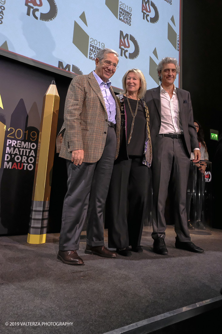 _DSF1541.jpg - 15/10/2019. Torino. Matita d'oro 2019. Anche quest'anno il Mauto ha assegnato i suoi prestigiosi premi al mondo dell'automobile. Nella foto Il premio MAUTO â€œCarlo Biscaretti di Ruffiaâ€� va allâ€™ Ing Mauro Forghieri  lâ€™insuperabile creativitÃ  ingegneristica e gli straordinari successi ottenuti su strada e su pista: durante gli anni in cui Ã¨ stato Direttore Tecnico della Scuderia Ferrari. Consegnano il premio  Mariella Mengozzi e Benedetto Camerana.