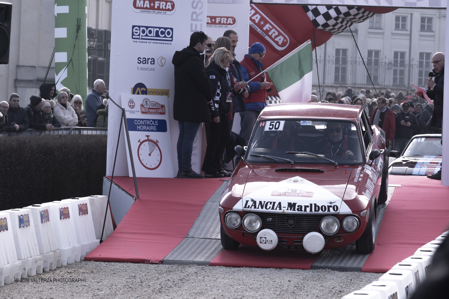 _DSF3948.jpg - La 28Âª edizione del Rallye Monte-Carlo Historique si svolge fino al 7 febbraio 2026 , ad eccezione della cittÃ  scozzese di  John O'Groats le varie cittÃ  di partenza hanno dato il via alla gara domenica 1 febbraio 2026. Tra queste anche Torino, la partenza Ã¨ avvenuta dalla Palazzina di caccia di Stupingi dove le vetture in gara hanno prima sostato in mostra nel parco partenze antistante la Palazzina. Nella foto vettura alla partenza ancia Fulvia HF 1.6 1969
