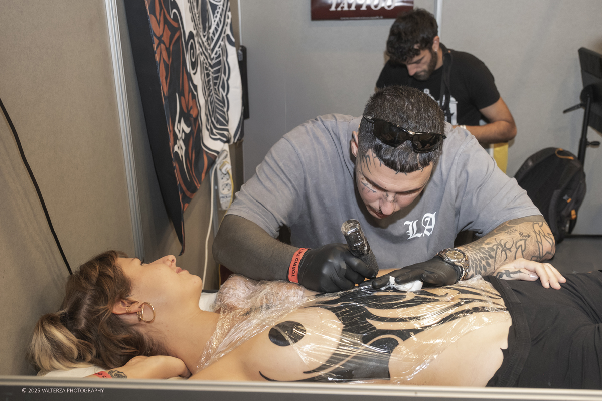 DSCF0123.jpg - 27/09/2025. Torino. Alla Tattoo Convention Edizione 2025. L'evento che celebra l'arte del tatuaggio. Nella foto tatuatore/tatuatrice al lavoro nel suo stand
