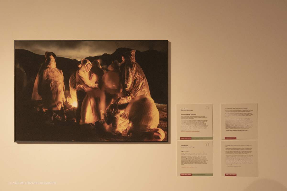 _DSF0236-2.jpg - World Press Photo Exhibition 2025 all’Accademia Albertina di Torino Il percorso espositivo presenta i lavori pubblicati dalle più autorevoli testate internazionali – da National Geographic a BBC, da CNN a Le Monde ed El PaÃs – e si conferma uno degli appuntamenti più attesi  per chi vuole comprendere il mondo attraverso lo sguardo dei reporter. Nella foto Immagine finalista Fotografo John Moore Un gruppo di migranti cinesi si scalda dopo aver attraversato il confine tra Stati Uniti e Messico.