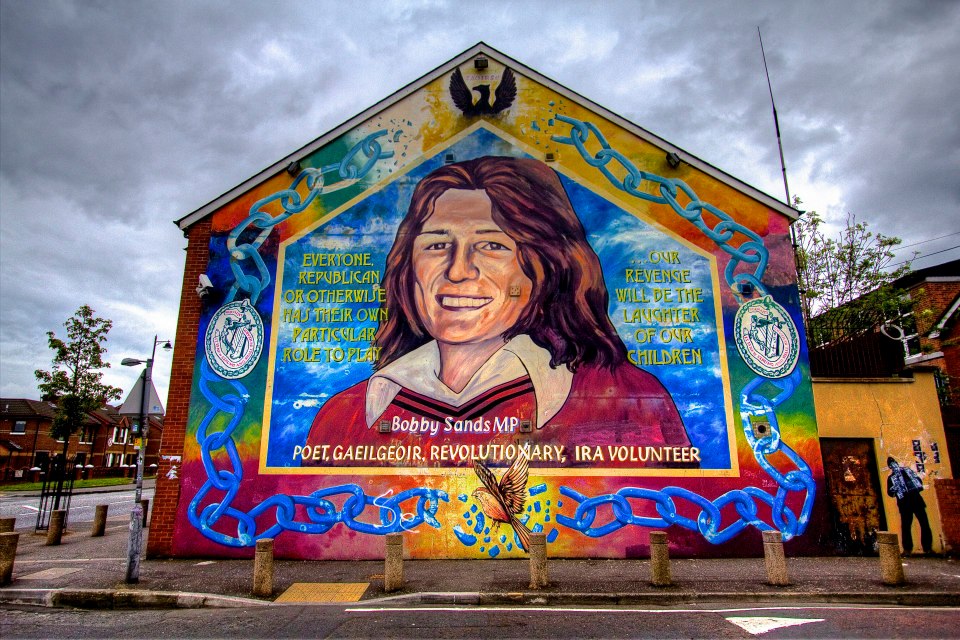 57.jpg - Il murale più famoso è quello dell'eroe locale Bobby Sands. Questi era un volontario della Provisional Irish Republican Army, fu eletto membro del Parlamento britannico mentre era detenuto nel carcere di Maze, a Long Kesh. Qui morì il 5 maggio 1981 a seguito di uno sciopero della fame condotto ad oltranza come forma di protesta contro il regime carcerario cui erano sottoposti i detenuti repubblicani.