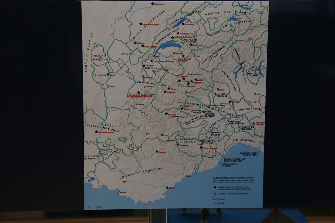 LoScrignoDelCardinale_38.jpg - Limoges in Piemonte La cartina mostra bene la straordinaria diffusione delle oreficerie di Limoges tra Piemonte, Valle d’Aosta e Savoia  nel corso del Medioevo.  Un censimento complessivo - avviato in occasione del progetto interdisciplinare MEMIP  [Medieval enamels, ivories and metalwork in Piedmont:art historicaland scientific methods for their evaluation, 2009-2017) -  ha consentito di rilevareun centinaio di testimonianze nell’area in esame.  Oggetti profani, come i candelieri qui esposti, oppure sacri: croci, piccoli crocifissi, reliquiari, pissidi, pastorali.  Il successo di queste oreficerie,  — prodotte tra XII e XIII secolo nel piccolo centro di Limoges, nel ducato di Aquitania —  si deve a due fattori: i colori splendenti, ottenuti con la tecnica dello smalto champlevé policromo,  e un prezzo ai mercato basso, dal momento che le opere erano realizzate in rame dorato  e non con metalli nobili.